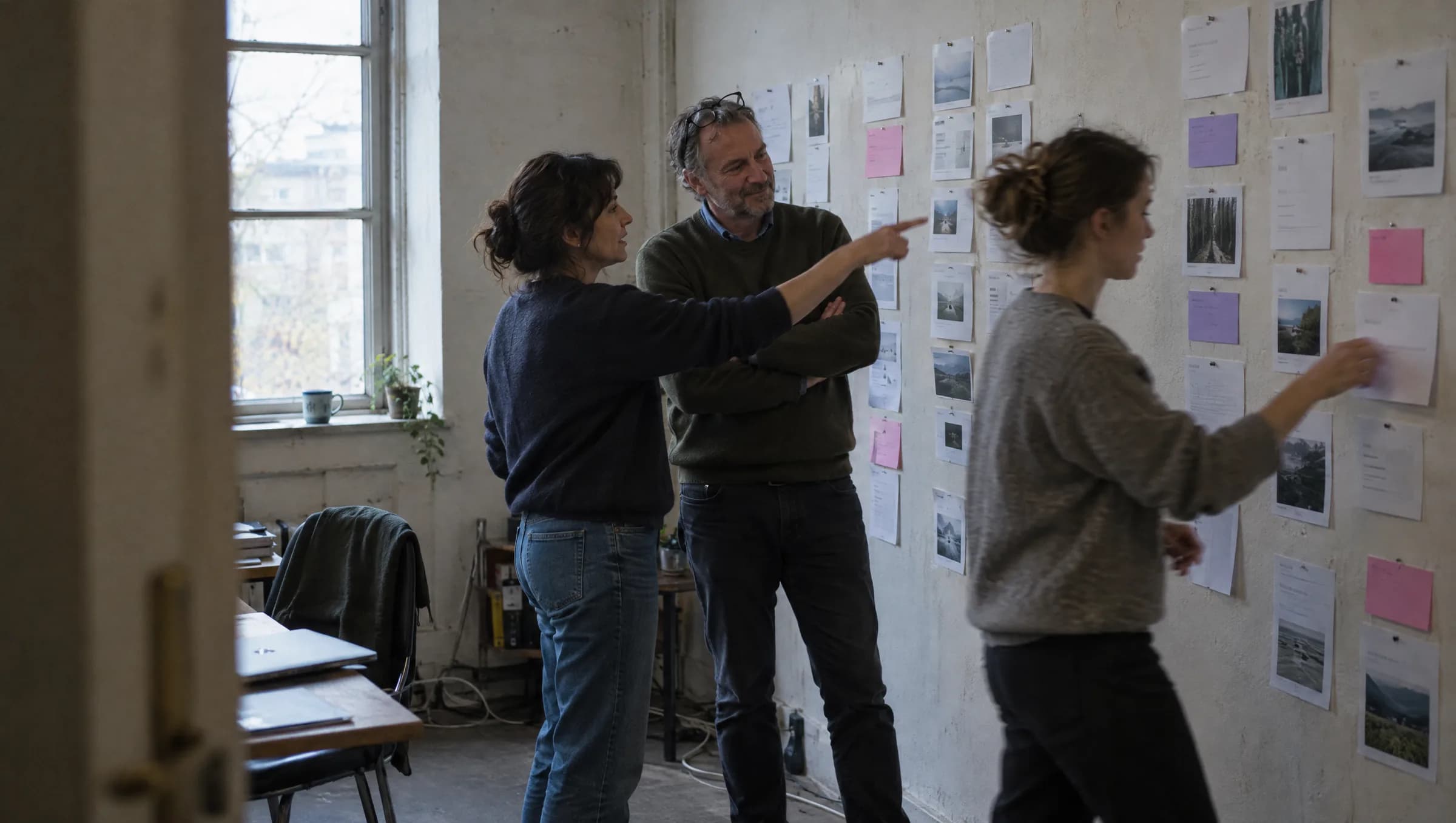 Three colleagues planning the week's releases in front of a wall of pinned cards in the studio